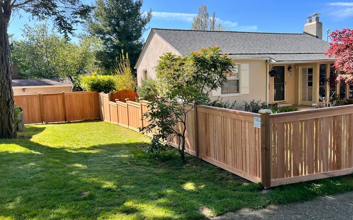 Cedar-toned wood fence around the side yard of a single-story house